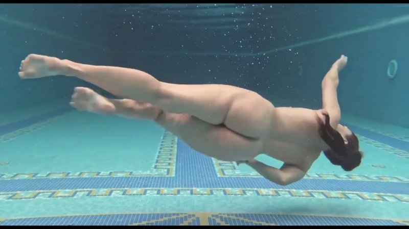 Девушка плавает в бассейне голая