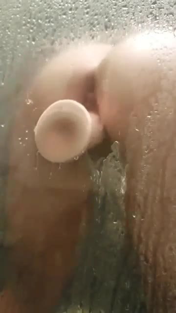 Зрелка насаживается на дилдак раком в душевой кабинке